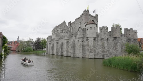 Tourist boat on River Lys at the Castle of the Counts (Gravensteen) in Ghent, Belgium photo