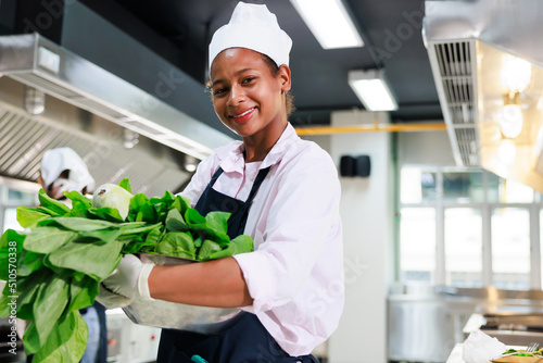 portrait young teen girl cook student. Cooking class. culinary classroom. happy young african woman students holding fresh vegetables for cooking in cooking school.