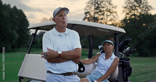 Rich couple enjoy golf evening on fairway. Family golfers relax summer holiday.