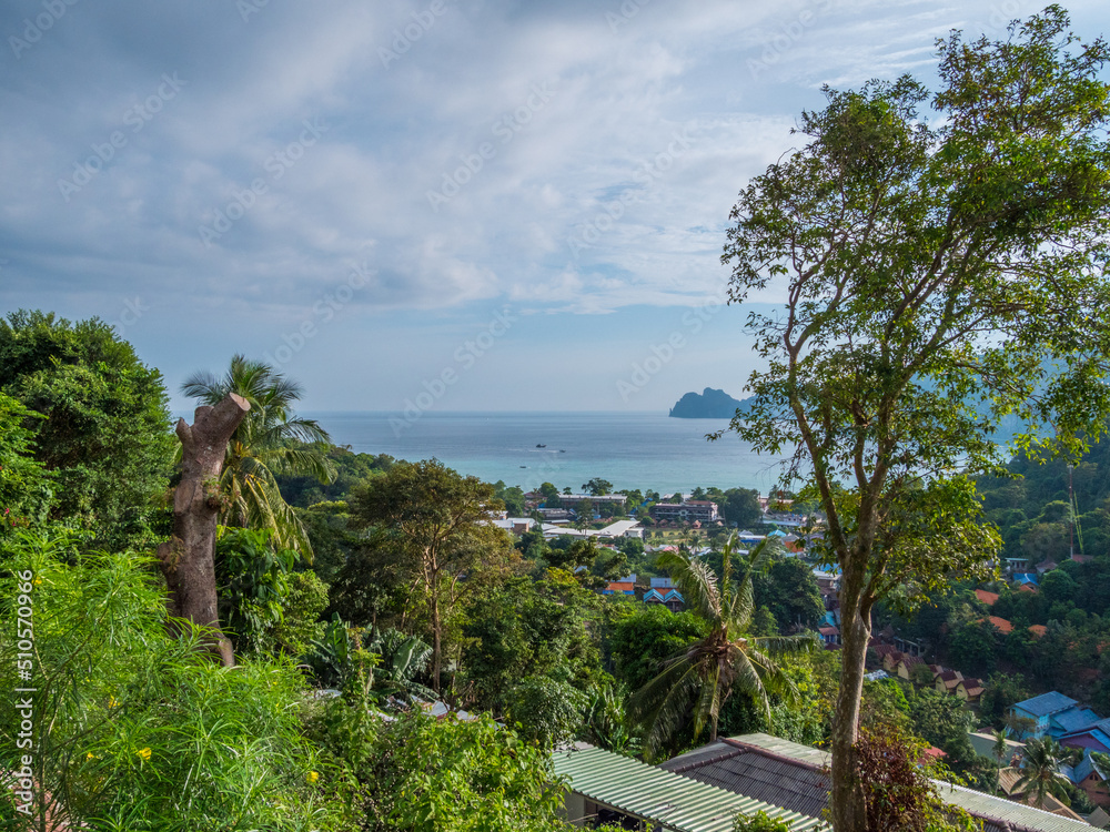 The view overlooking the town.  Blue sky over green mountains. Amazing view of the ocean. Thailand