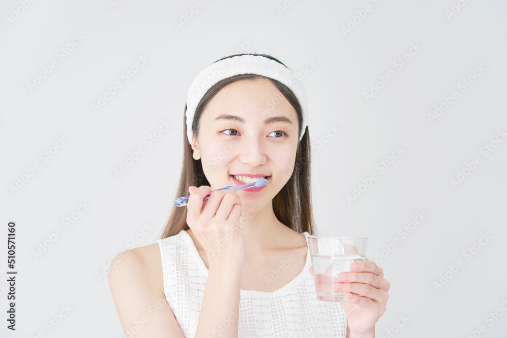 白背景で歯磨きする女性 白背景で歯磨きする女性