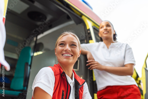 Two female nurses by the ambulance. Two paramedics by the ambulance, smiling. photo