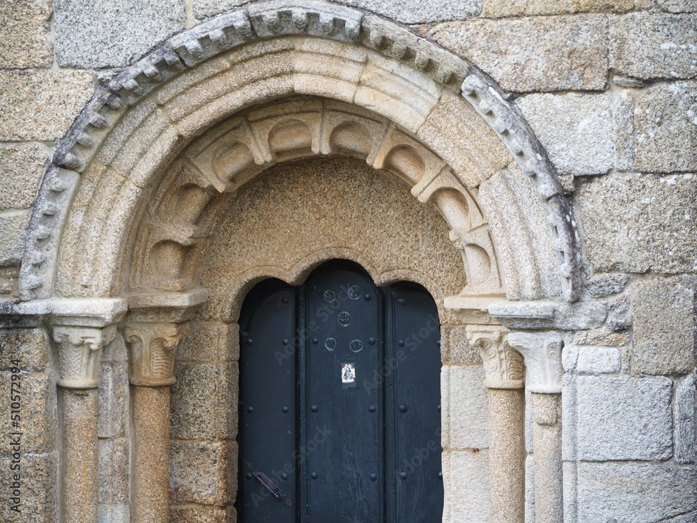 puerta oeste de la iglesia de santa maria de mezonzo, puerta entre dos columnas, tres arquivoltas, timpano liso, mensulas y capiteles decorados con motivos vegetales, arquillos ciegos, la coruña, espa