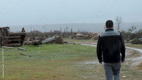 Man walks alone in a place that is devastated after a natural disaster.