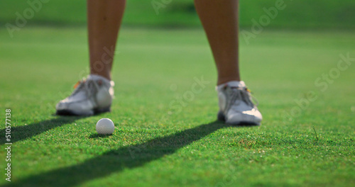 Woman legs play golf game match on grass course. Golfer hitting ball outside.