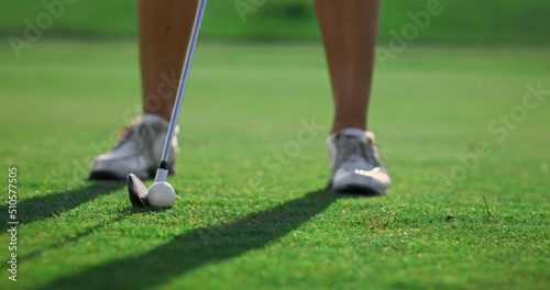 Lady golfer legs training wear white sneakers at country club course grass field