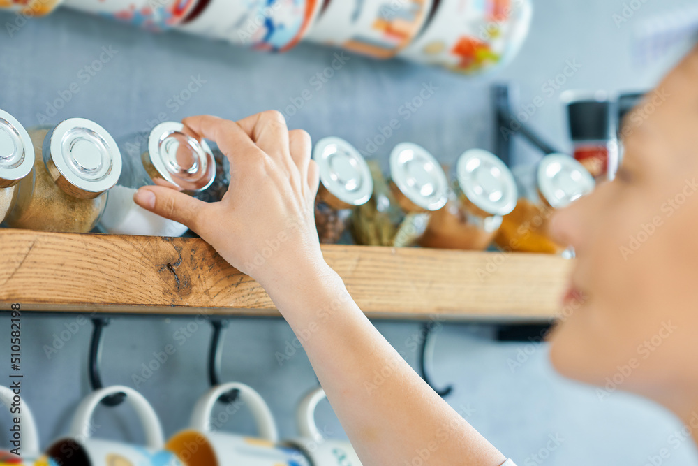 Young woman looking for spices in the kitchen