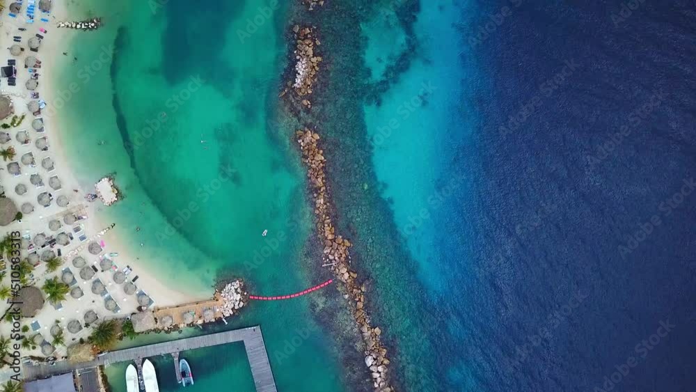 Tilt up aerial view of Mambo Beach with rock breakwater, Curacao, Dutch Caribbean island Tilt up aerial view of Mambo Beach with rock breakwater, Curacao, Dutch Caribbean island