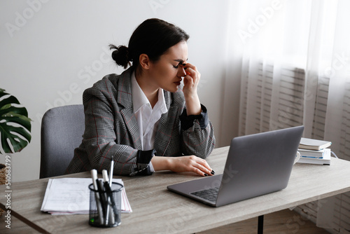 Portrait of a young businesswoman in a state of emotional, physical and mental exhaustion caused by excessive work related stress. Professional burnout concept. Close up, copy space, background.