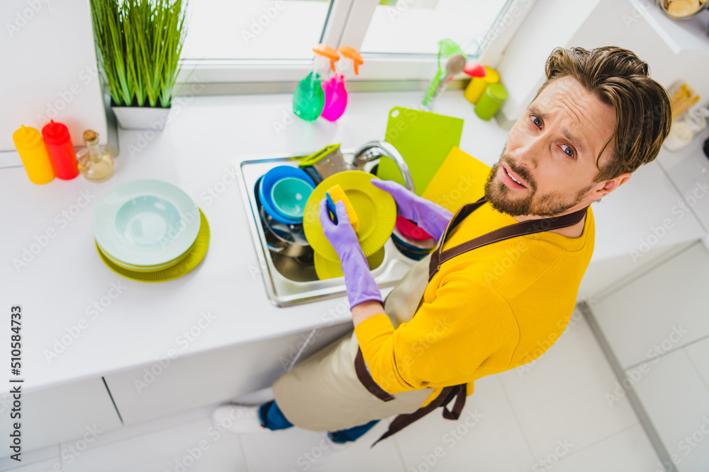 Top above high angle view photo of young man dishwash rub sponge clean plate kitchen service household indoors Top above high angle view photo of young man dishwash rub sponge clean plate kitchen service household indoors