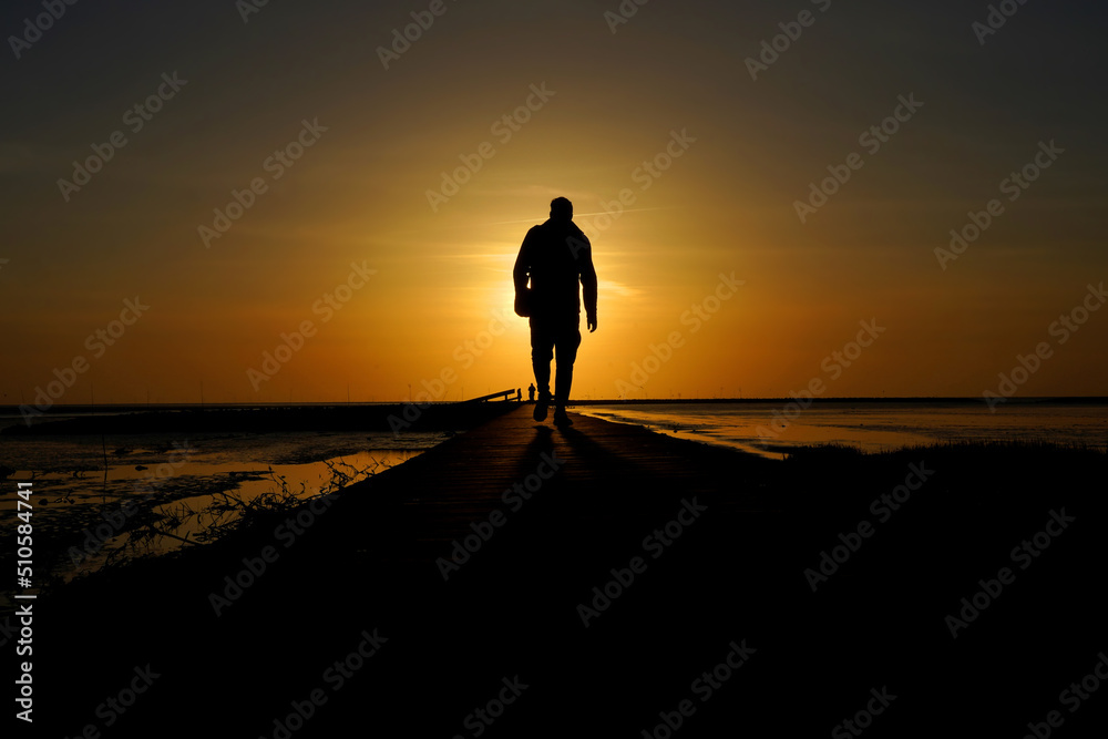 Silhouette of a man goes to meet the sunset.