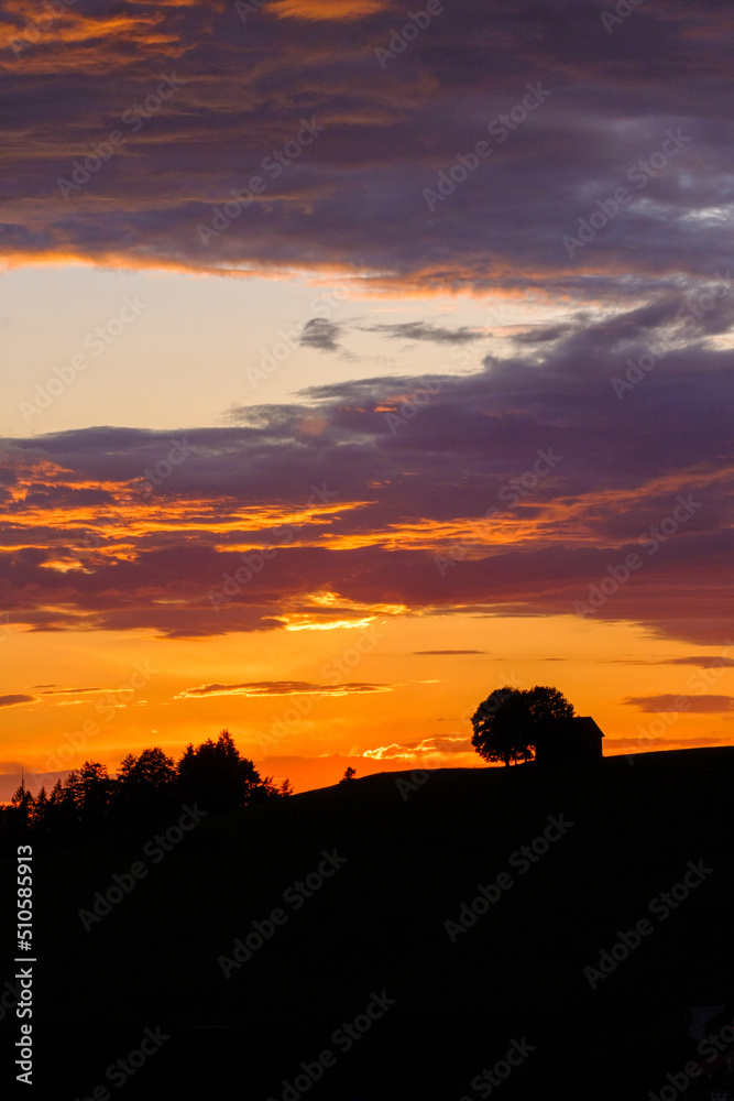 Abendstimmung in einer schönen Hügellandschaft mit Wiesen, Bäumen und Häusschen. Abendstimmung in einer schönen Hügellandschaft mit Wiesen, Bäumen und Häusschen.