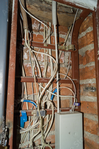 Electric cabinet with Internet and television cables in an apartment building. Niche for wires and cables inside the brick wall. Selective focus