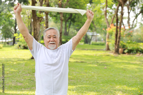 Asian senior man practice yoga excercise, tai chi tranining, stretching and meditation together with relaxation for healthy in park outdoor after retirement. Happy elderly outdoor lifestyle concept