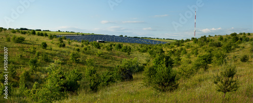 big panoramic view of large solar panel station on the hills on a summer land...