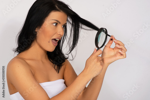 Caucasian woman looking at her hair, hair care concept, dry and damaged hair ends