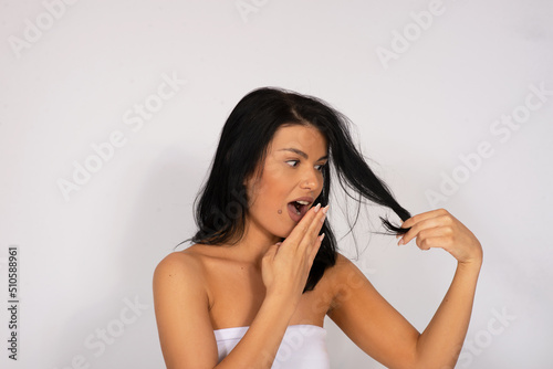Caucasian woman looking at her hair, hair care concept, dry and damaged hair ends