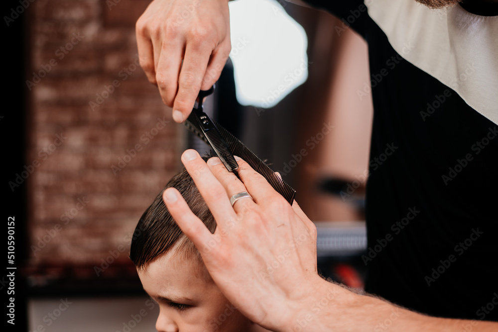 Children's haircut of a boy in a barbershop