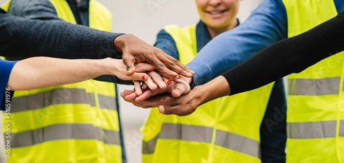 hands together of multiracial people, teamwork engineers in factory, workers hands together in warehouse photo
