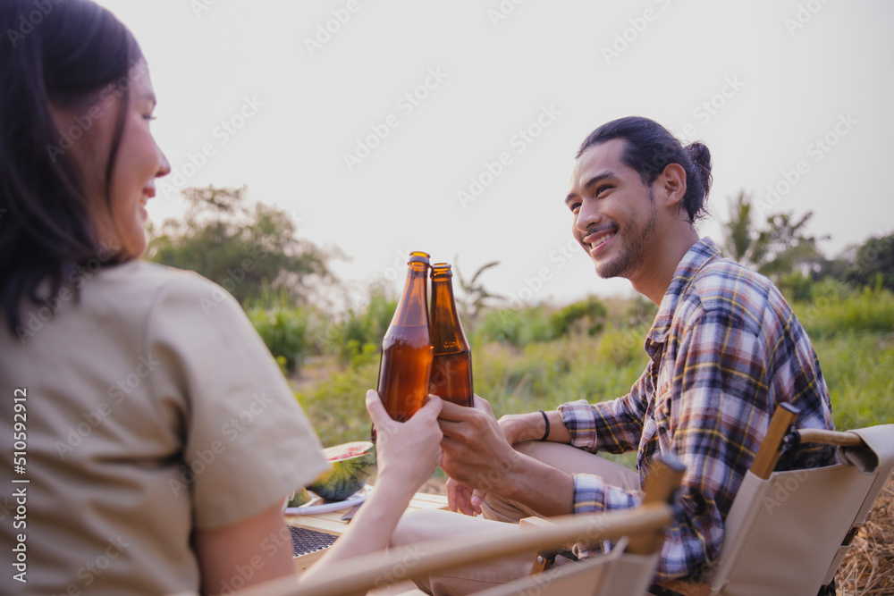 Camping trip of young Asian couple enjoy picnic countryside by drink Camping trip of young Asian couple enjoy picnic countryside by drink