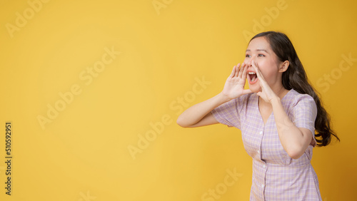 Woman teen standing big shout out with hands next mouth giving excited positive, present and call on orange background photo