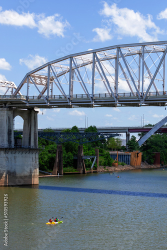 Kayakers paddling under the John Seigenthaler Pedestrian Bridge on the Cumberland River in Nashville, Tennessee.. Photographer Derek Broussard