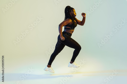 Black young woman with afro pigtails running while working out
