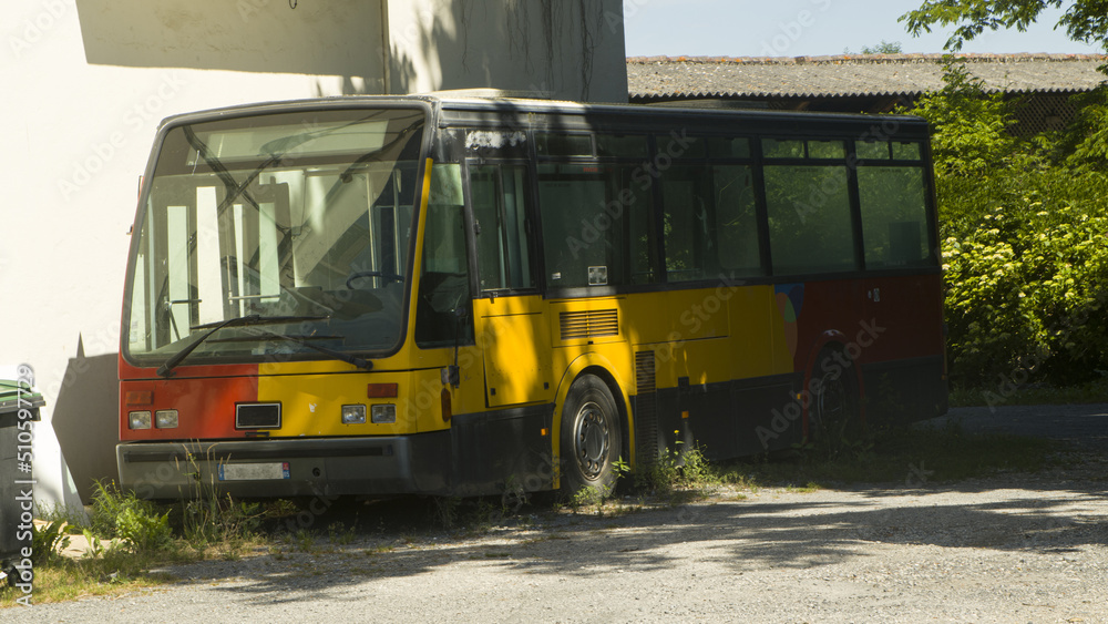 vieux bus jaune et rouge abandonné a la campagne. véhicule a l'abandon ,en panne