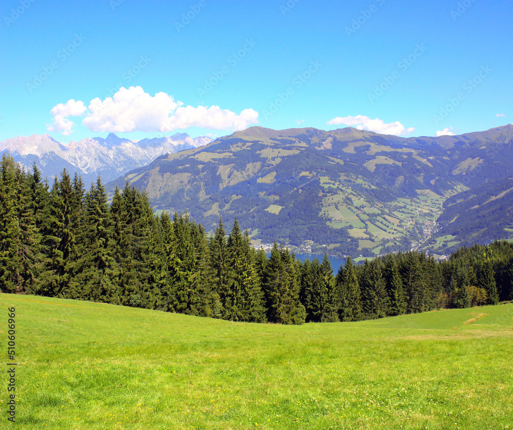 Alps mountains in Tirol, Austria. Aerial view of idyllic mountain scenery in Alps with green grass and fur-trees on sunny day