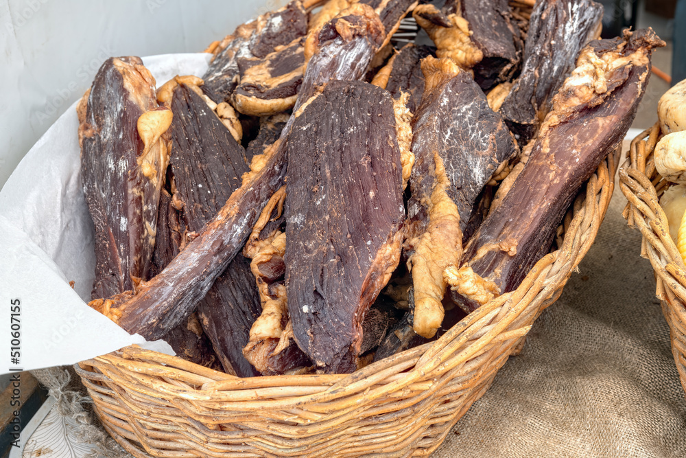 Pieces of homemade beef jerky in basket at farmers market. Close-up on tasty jerky meat snack. Pieces of homemade beef jerky in basket at farmers market. Close-up on tasty jerky meat snack.