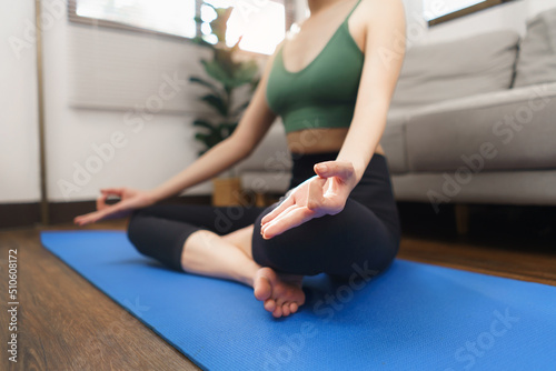 Yoga and wellness concept, Young Asian woman doing yoga with meditation in padmasana or lotus pose