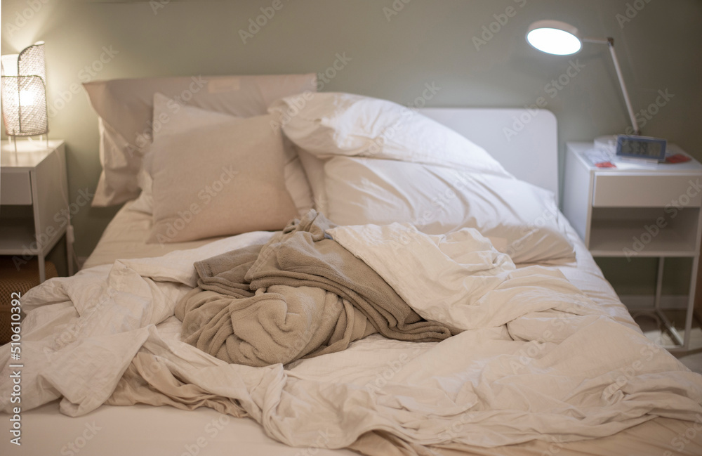 Picture of a bed with cluttered blankets