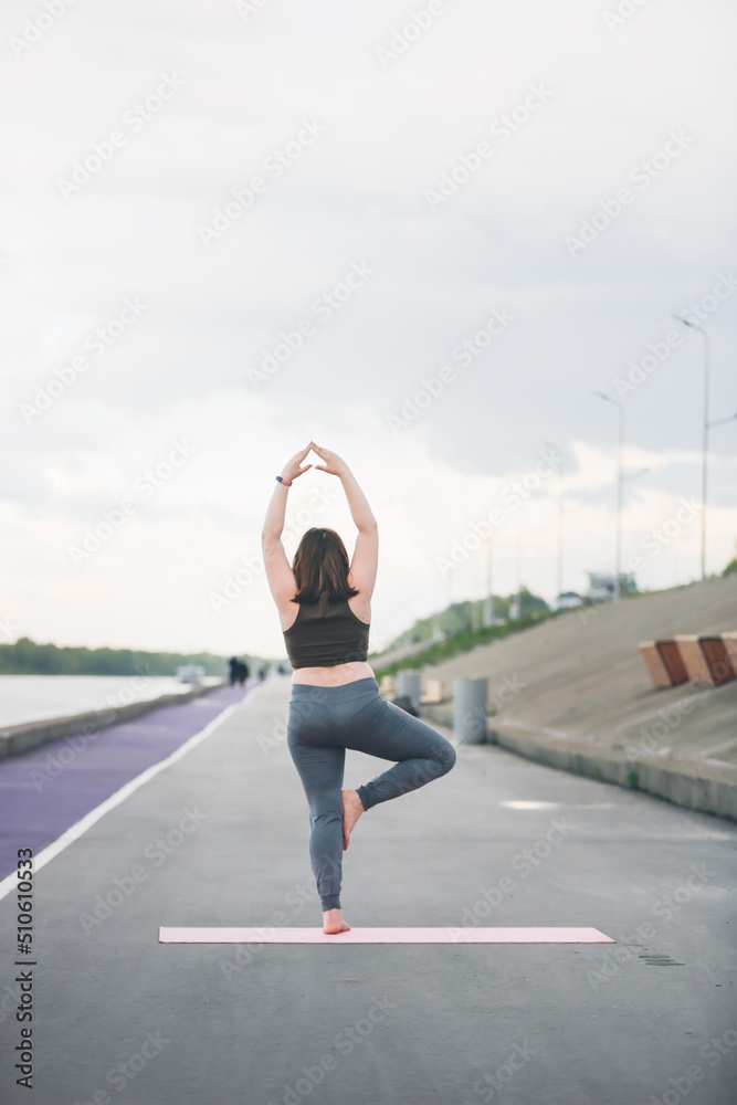 girl child teenager in sportswear with excess weight does exercises, plays sports outside in summer. girl child teenager in sportswear with excess weight does exercises, plays sports outside in summer.