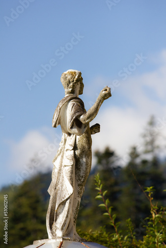 ancient stone statue with moss in old garden
