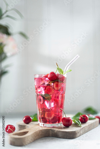cocktail with cherry juice, mint, and ice in a glass