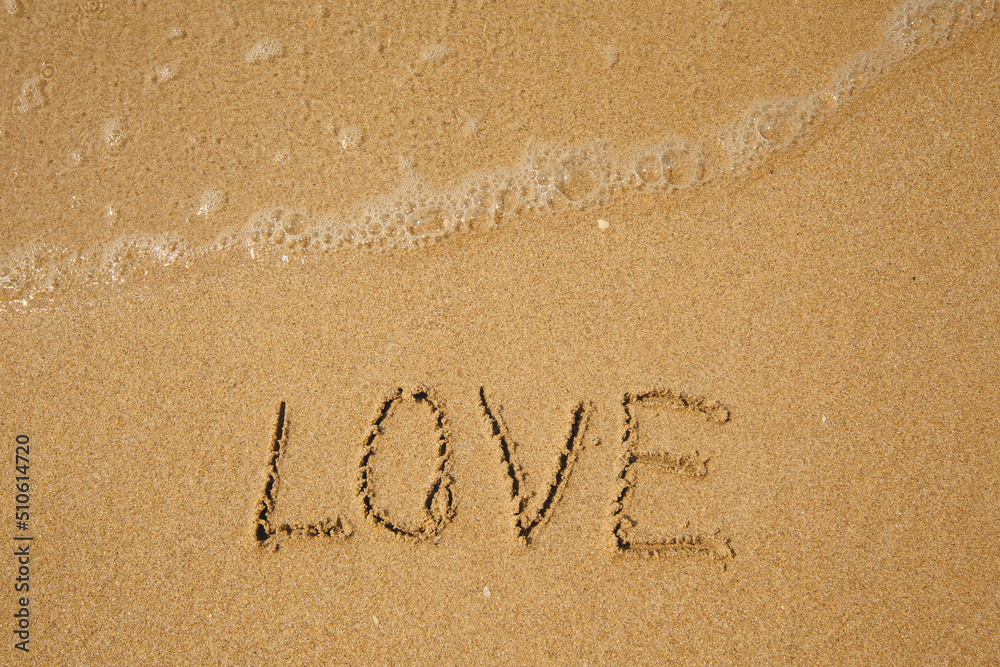 Fototapeta premium LOVE - handwritten on the soft beach sand.