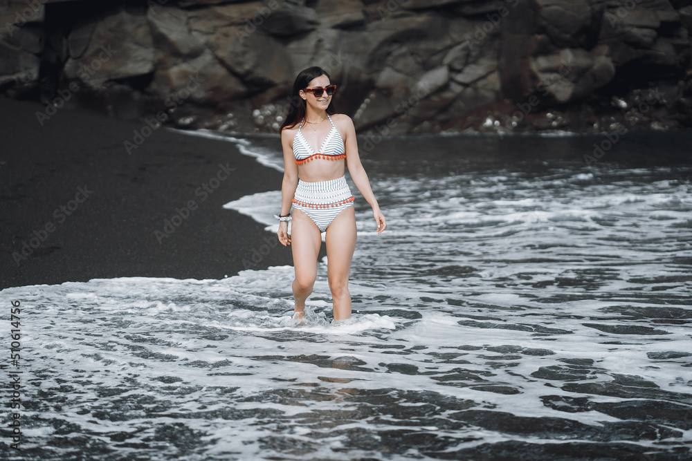 Fototapeta premium Girl in a stylish swimsuit have a rest n a beach