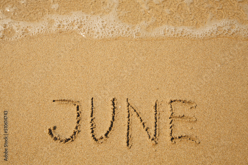 June - handwritten on the soft beach sand. © De Visu