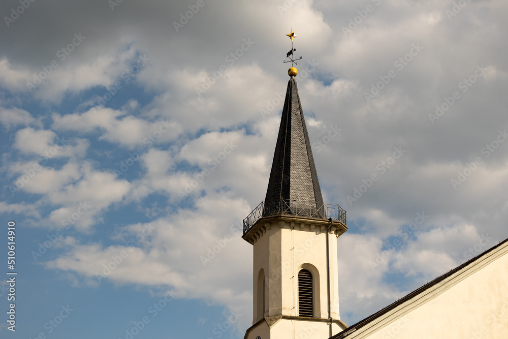 Friedrichsdorf, Hochtaunus, Hessen, Germany Mai 2022. Church tower of the Protestant church in Friedrichsdorf. Blue sky with clouds.