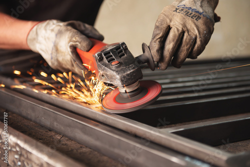 Professional male blacksmith forming red hot metal on an anvil in interior blacksmith workshop Fototapeta