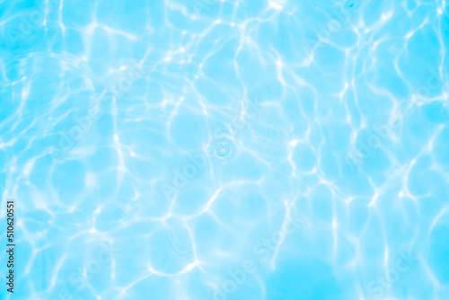 Blurred transparent blue colored clear calm water surface texture with splashes and bubbles. Trendy abstract nature background. Water waves in sunlight. water background