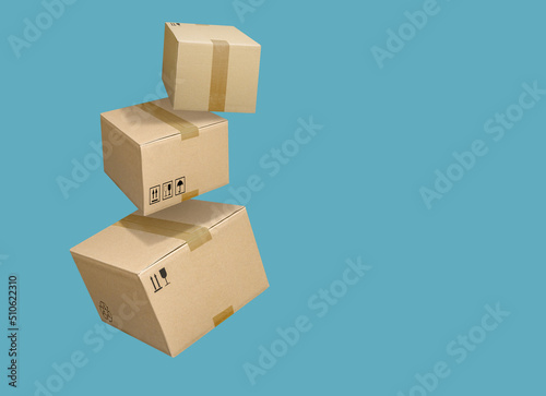 Cardboard parcel boxes falling on turquoise blue background