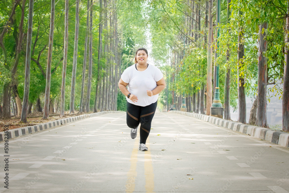 Overweight woman jogging at the park