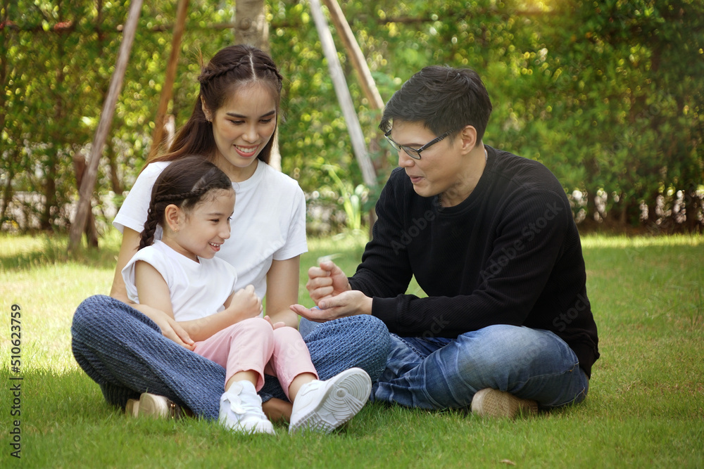 Daughters and children sit on the lap of mom and dad, families having fun picnics and playing together in the backyard. Daughters and children sit on the lap of mom and dad, families having fun picnics and playing together in the backyard.