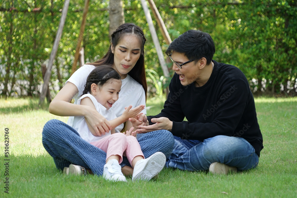 Daughters and children sit on the lap of mom and dad, families having fun picnics and playing together in the backyard. Daughters and children sit on the lap of mom and dad, families having fun picnics and playing together in the backyard.