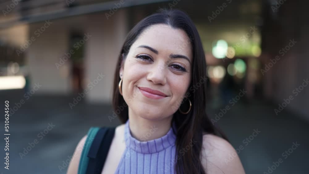 Positive brunette woman with backpack looking at the camera outdoors Positive brunette woman with backpack looking at the camera outdoors