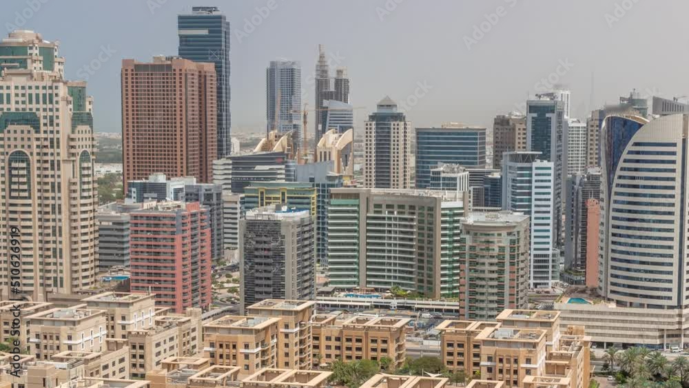 Skyscrapers in Barsha Heights district and low rise buildings in Greens district aerial timelapse during all day. Dubai skyline with palms and trees. Shadows moving fast Skyscrapers in Barsha Heights district and low rise buildings in Greens district aerial timelapse during all day. Dubai skyline with palms and trees. Shadows moving fast