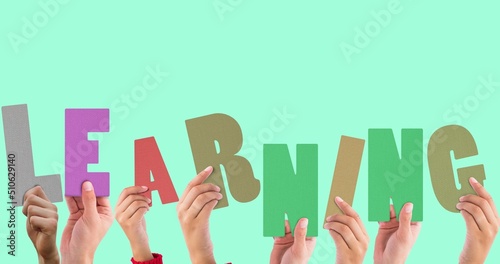 Cropped hands of multiracial people holding learning text against blue background, copy space