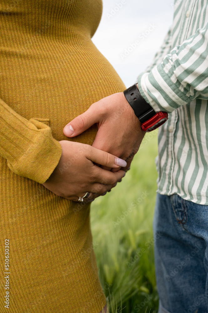 Parents pair hands touch pregnant mothers big stomach with baby