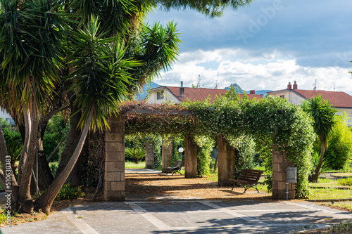 Small garden in the Italian province in the south. Beautiful arches with fresh flowers, comfort in the hot season.
